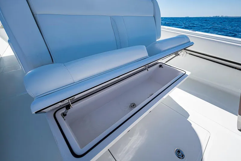 Slide: The Image of 2017 Bahama 41 boat with open storage compartment, showcasing sleek seating and ocean backdrop. - 22