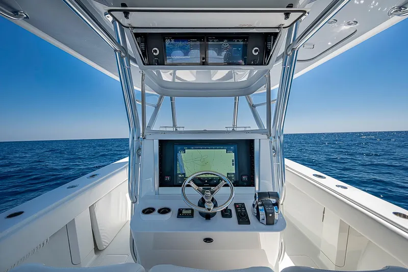 Slide: The Image of Helm of 2017 Bahama 41 boat with navigation screens, steering wheel, and ocean view. - 26