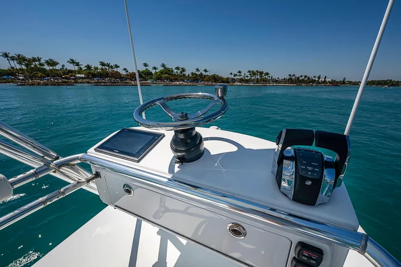 Slide: The Image of Helm of 2017 Bahama 41 boat with steering wheel and controls, overlooking tropical waters. - 45