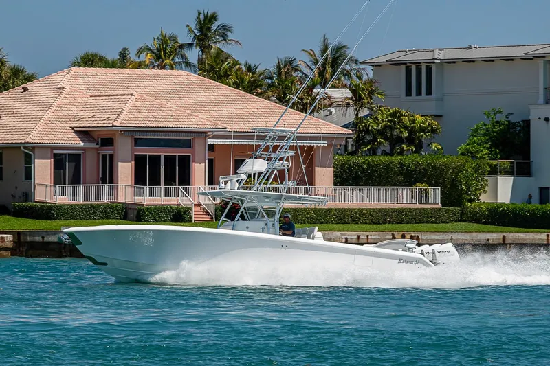 Slide: The Image of 2017 Bahama 41 boat cruising near waterfront homes, clear blue sky. - 6