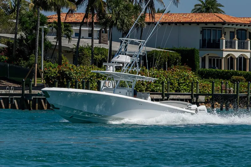 Slide: The Image of 2017 Bahama 41 boat cruising near waterfront homes with lush greenery. - 7