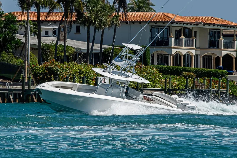 Slide: The Image of 2017 Bahama 41 boat cruising near waterfront homes with palm trees. - 8