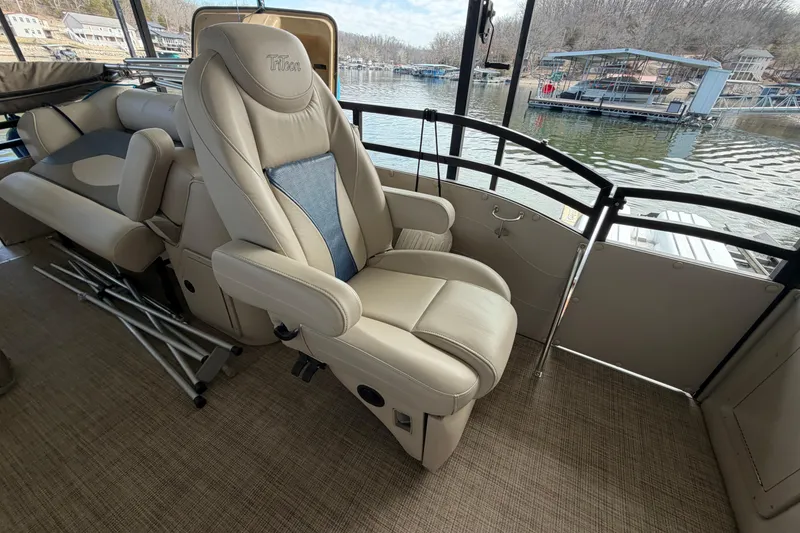 Slide: The Image of Luxurious seating on 2018 JC 25 Neptoon TT Sport pontoon boat, docked by a serene lake. - 16
