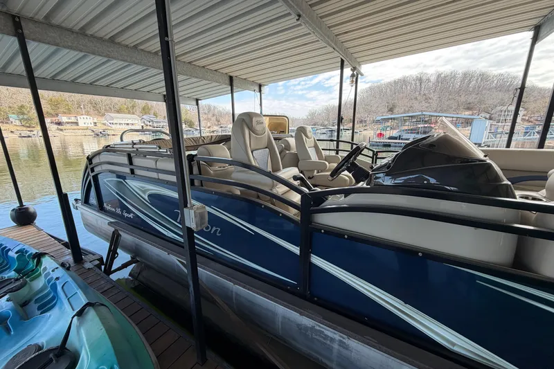 Slide: The Image of 2018 JC 25 Neptoon TT Sport pontoon boat docked under a covered marina. - 7