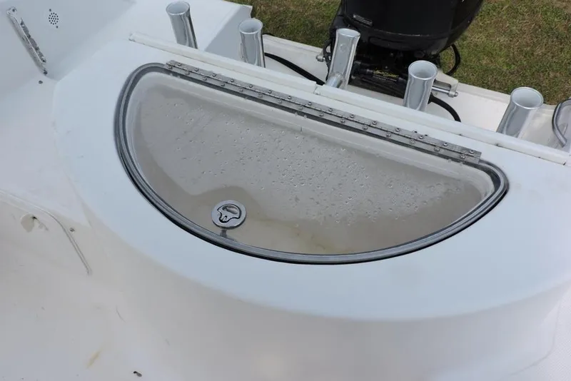 Slide: The Image of Livewell on 2007 Sea Fox 216 Center Console boat, featuring rod holders and motor. - 7