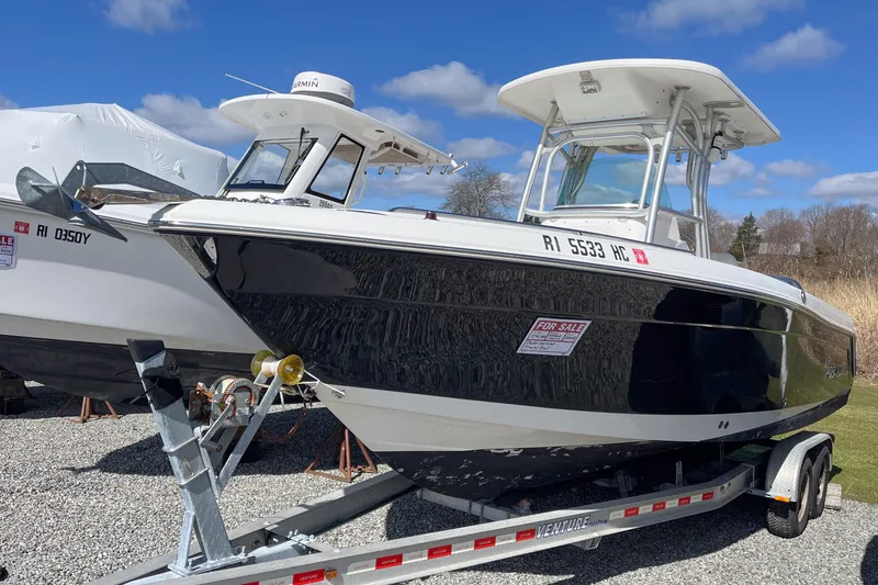 The Image of 2008 Robalo R260 Center Console boat on trailer, for sale under clear blue sky. - 0
