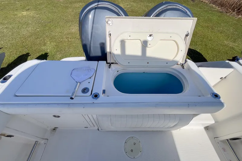 Slide: The Image of 2008 Robalo R260 Center Console boat with open storage compartment and fishing net. - 3