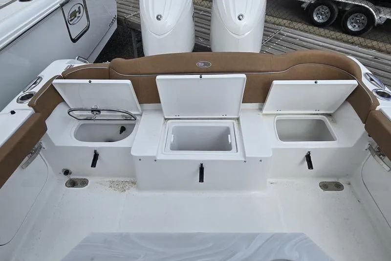 Slide: The Image of 2026 Sea Hunt Ultra 265 SE boat with open storage compartments and seating area. - 5