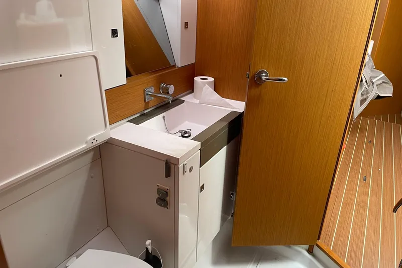 Slide: The Image of Bathroom interior of 2016 Jeanneau Sun Odyssey 44 DS yacht, featuring sink and wooden cabinetry. - 14