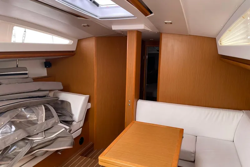 Slide: The Image of Interior of 2016 Jeanneau Sun Odyssey 44 DS yacht with wood finish and white seating. - 17