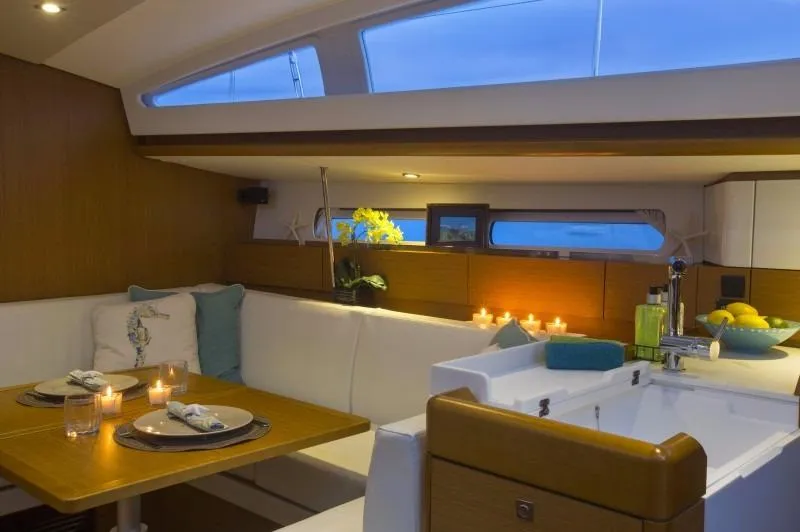 Slide: The Image of Manufacturer Provided Image: Interior of 2016 Jeanneau Sun Odyssey 44 DS yacht with elegant dining area and ambient lighting. - 5