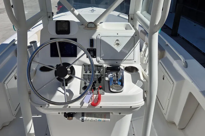 Slide: The Image of 2005 Everglades 223 Center Console boat helm with steering wheel and controls. - 11