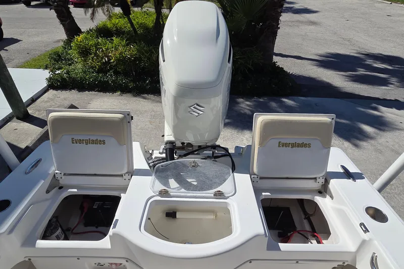 Slide: The Image of 2005 Everglades 223 Center Console boat with open storage compartments and outboard motor. - 2