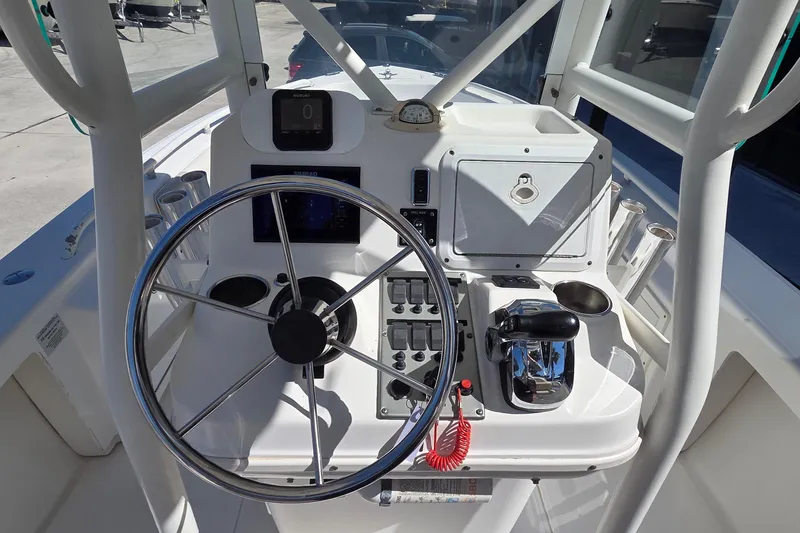Slide: The Image of 2005 Everglades 223 Center Console boat helm with steering wheel and controls. - 8