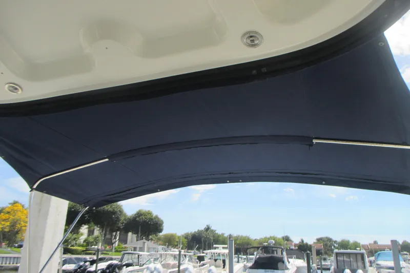 Slide: The Image of Bimini top on a 2005 Sea Ray 390 Sundancer, docked with other boats. - 16