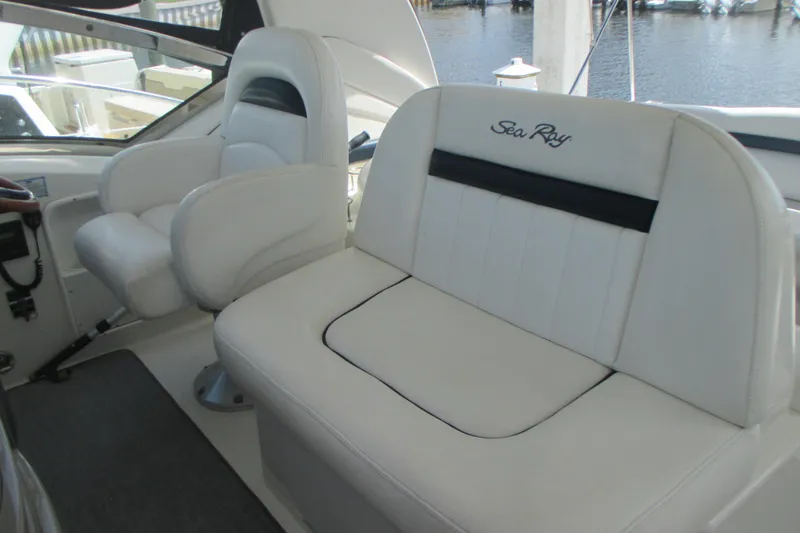 Slide: The Image of 2005 Sea Ray 390 Sundancer cockpit with white leather seating and helm chair. - 18