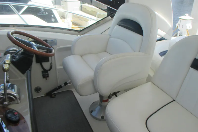 Slide: The Image of Helm of 2005 Sea Ray 390 Sundancer with white captain's chair and wooden steering wheel. - 19