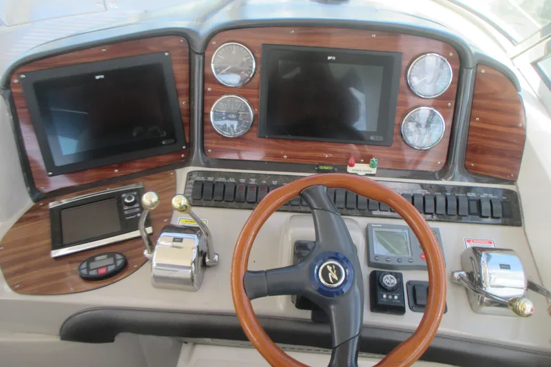 Slide: The Image of 2005 Sea Ray 390 Sundancer helm with wood accents and modern navigation controls. - 22