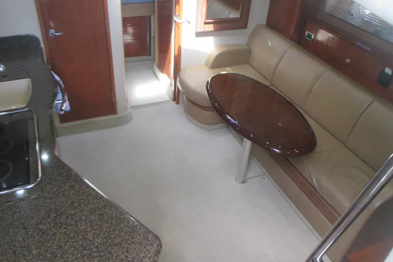Slide: The Image of Interior of 2005 Sea Ray 390 Sundancer yacht with beige seating and wooden table. - 23