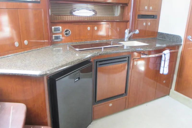 Slide: The Image of Luxurious 2005 Sea Ray 390 Sundancer yacht kitchen with wood cabinetry and granite countertops. - 24