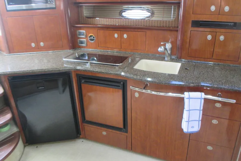 Slide: The Image of 2005 Sea Ray 390 Sundancer yacht kitchen with wood cabinets and granite countertops. - 26