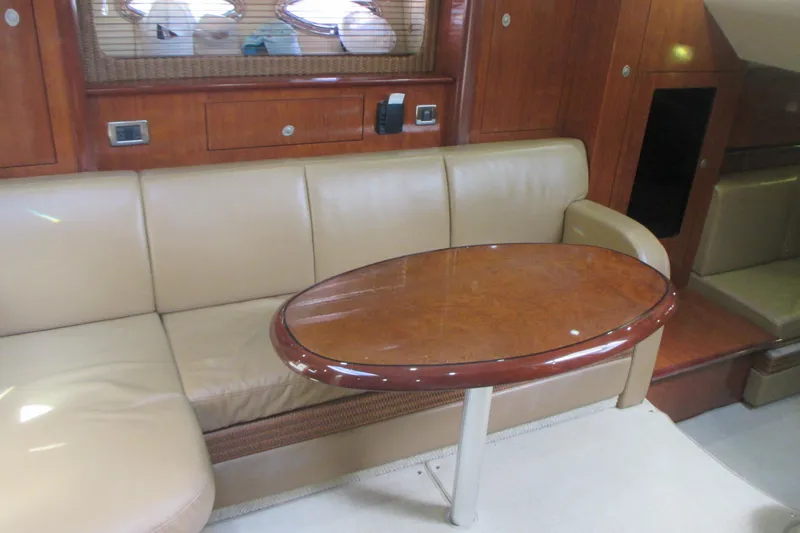Slide: The Image of Interior of 2005 Sea Ray 390 Sundancer with beige leather seating and wooden table. - 29