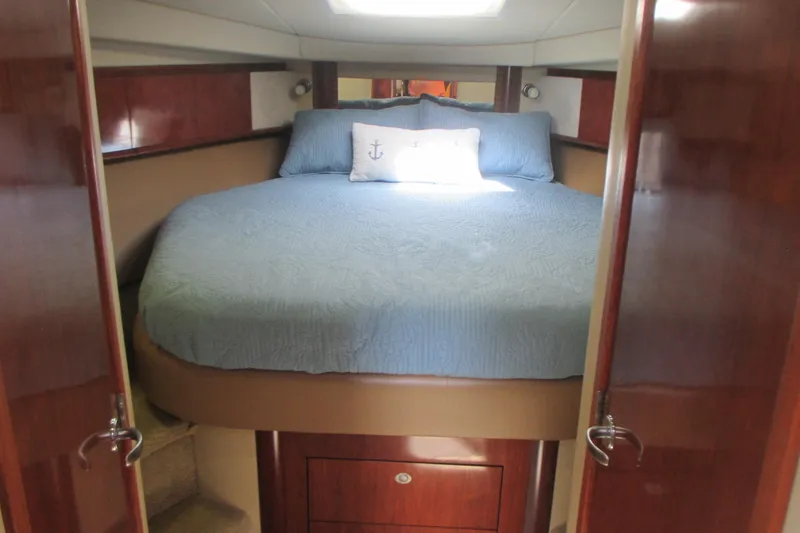 Slide: The Image of 2005 Sea Ray 390 Sundancer cabin with a cozy bed and nautical decor. - 30