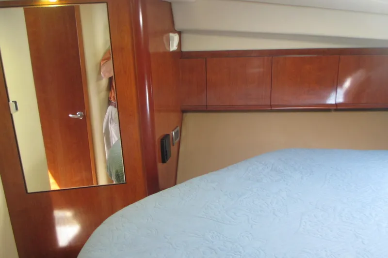 Slide: The Image of Interior cabin of 2005 Sea Ray 390 Sundancer with wood paneling and bed. - 32