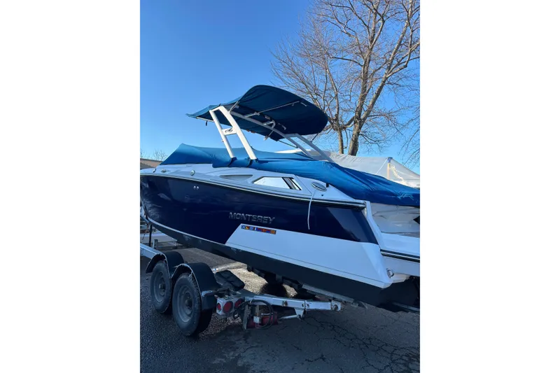 Slide: The Image of 2023 Monterey 278SS Super Sport boat on trailer, blue cover, clear sky background. - 3