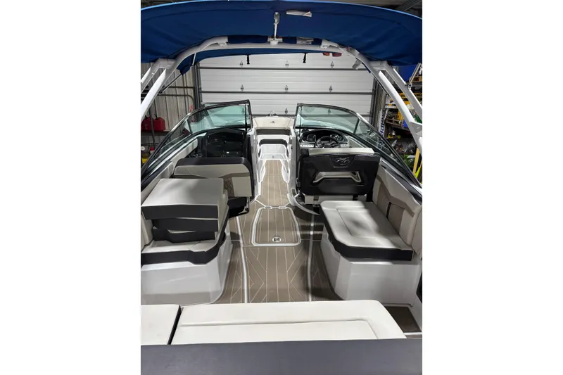 Slide: The Image of 2023 Monterey 278SS Super Sport boat interior with seating and dashboard, under blue canopy. - 5