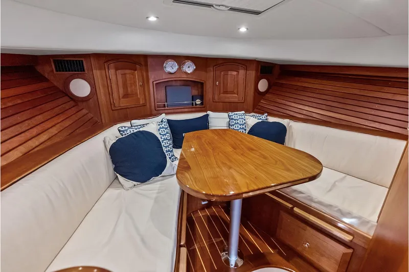 Slide: The Image of Luxurious interior of 2008 Hinckley Talaria 38R with wooden table and cushioned seating. - 19