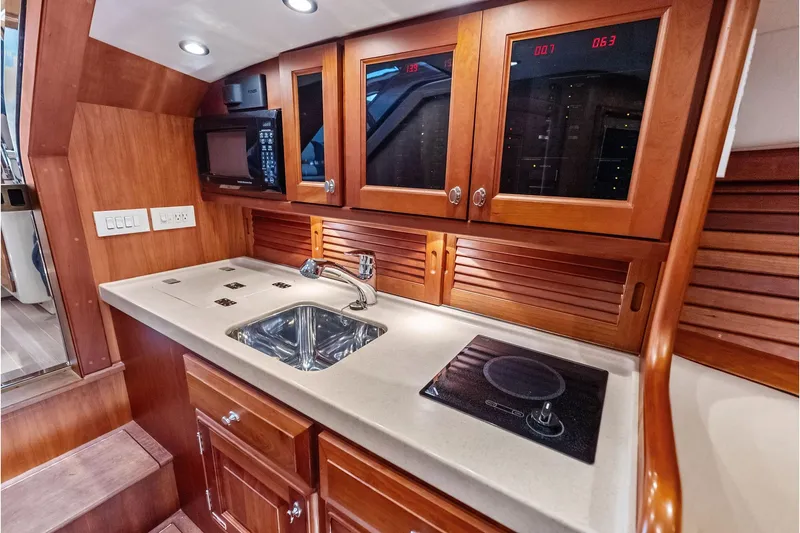Slide: The Image of Luxurious 2008 Hinckley Talaria 38R yacht kitchen with wood cabinetry and modern appliances. - 20