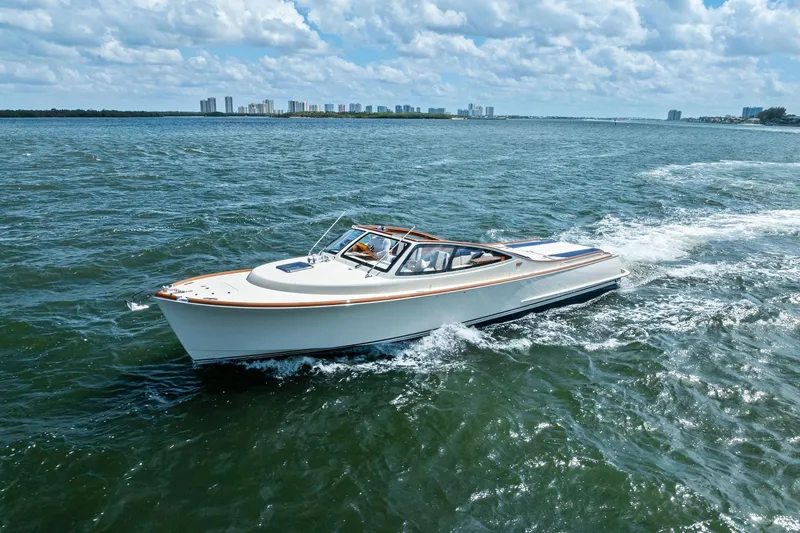 Slide: The Image of 2008 Hinckley Talaria 38R cruising on open water under a cloudy sky. - 5