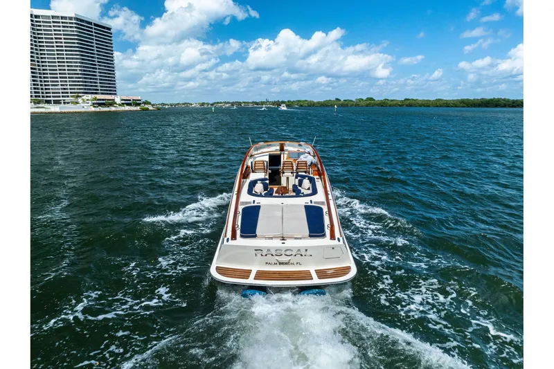 Slide: The Image of 2008 Hinckley Talaria 38R cruising on a sunny day near a coastal cityscape. - 6