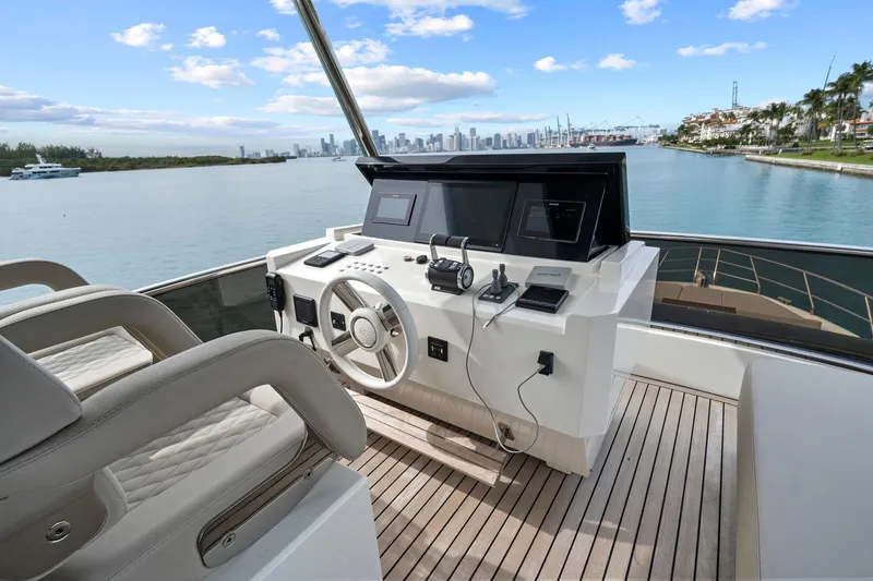 Slide: The Image of Flybridge helm of 2022 Astondoa 66 yacht with modern controls and waterfront view. - 14