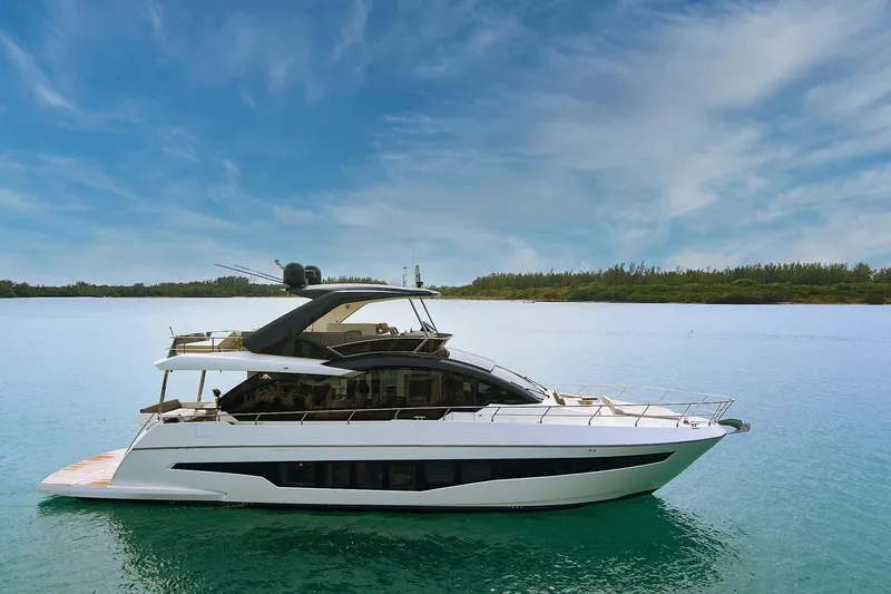 Slide: The Image of 2022 Astondoa 66 Flybridge yacht cruising near luxury waterfront residences. - 3