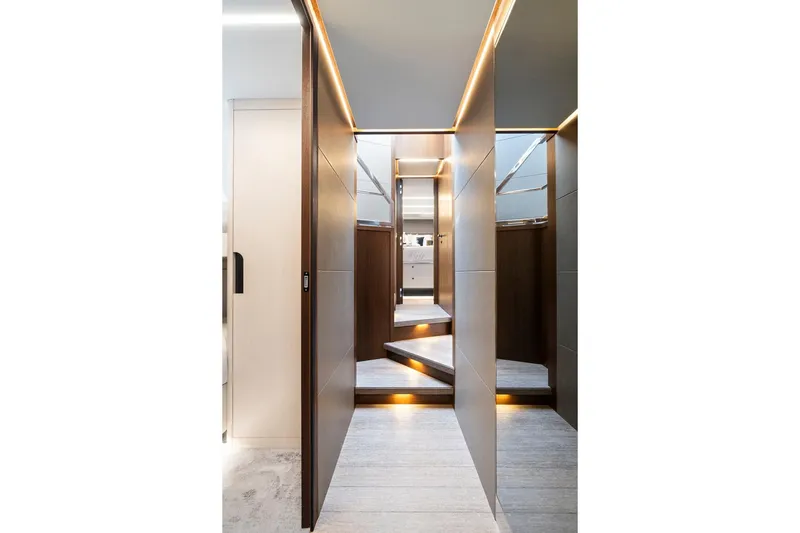 Slide: The Image of Staircase inside 2022 Astondoa 66 Flybridge yacht, featuring sleek wood and metal design. - 38