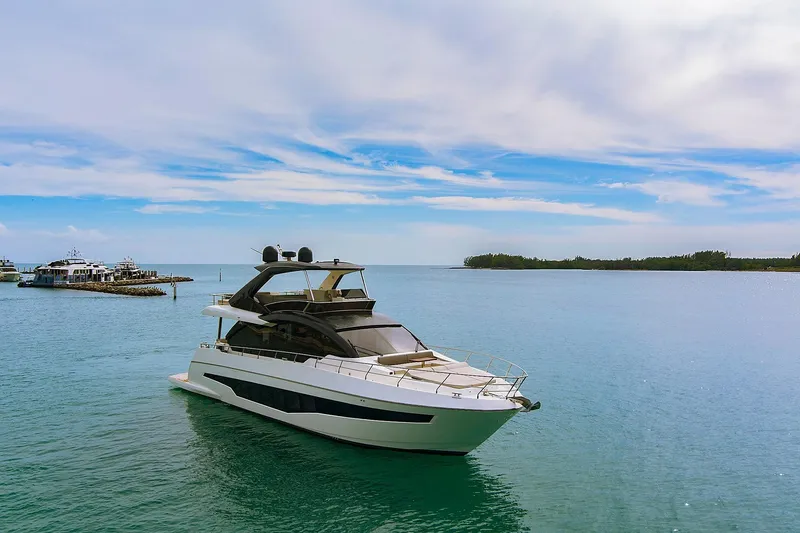 Slide: The Image of 2022 Astondoa 66 Flybridge yacht cruising near luxury waterfront homes. - 4