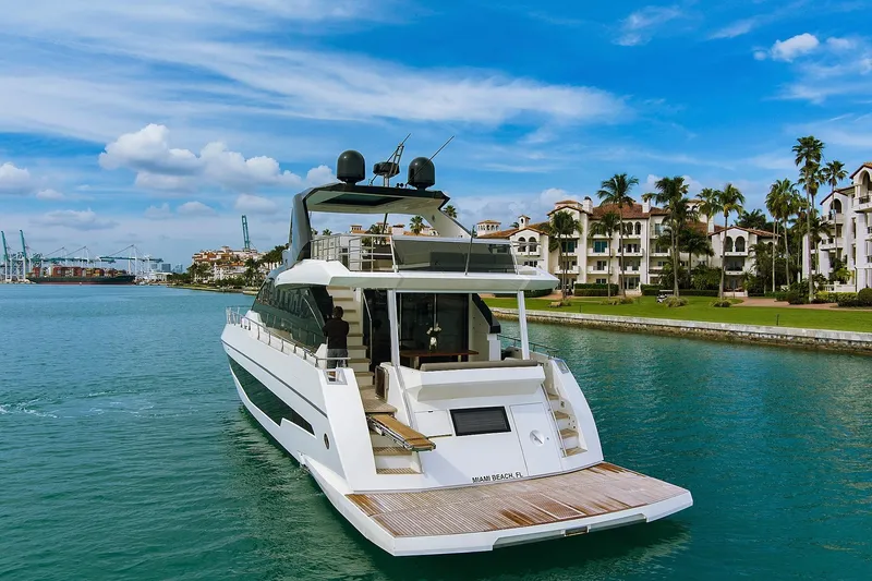 Slide: The Image of 2022 Astondoa 66 Flybridge yacht cruising on calm blue waters under a clear sky. - 6