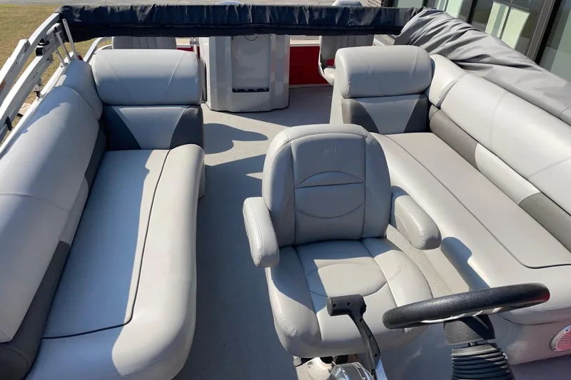 Slide: The Image of 2016 Silver Wave 230 Island CC boat interior with gray seating and steering wheel. - 8
