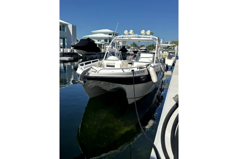 Slide: The Image of 2007 ProKat 2560 DC boat docked in a marina under clear blue skies. - 2
