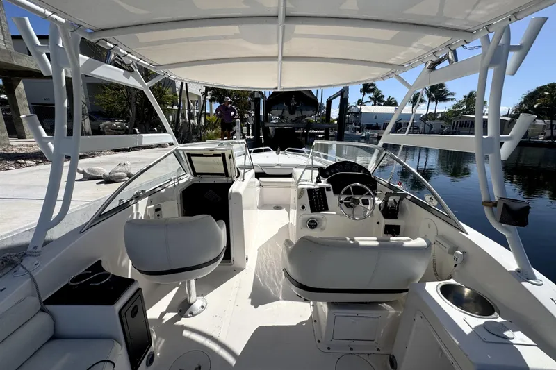 Slide: The Image of 2007 ProKat 2560 DC boat interior with steering wheel and seating, docked by the water. - 8