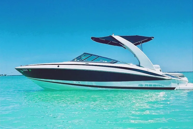 Slide: The Image of 2012 Regal 2500 Bowrider boat on clear turquoise water under blue sky. - 1