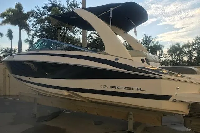 Slide: The Image of 2012 Regal 2500 Bowrider boat with sleek design, docked outdoors under a clear sky. - 3