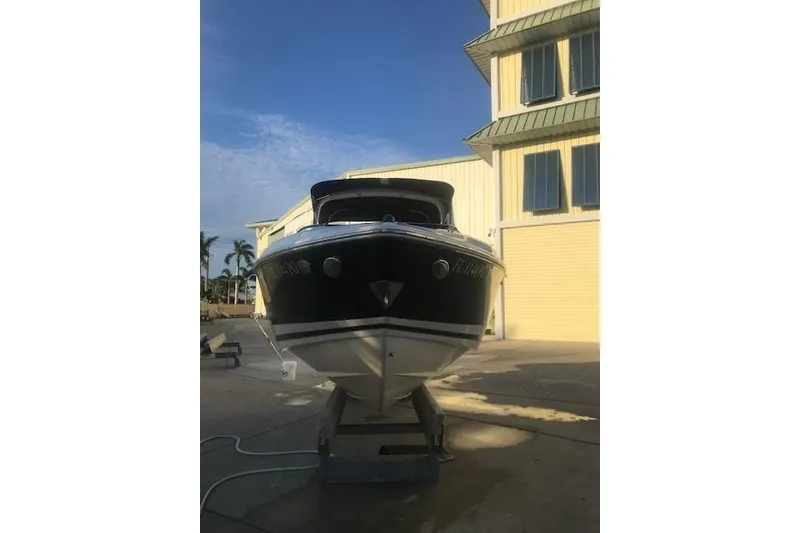 Slide: The Image of 2012 Regal 2500 Bowrider boat on a trailer, parked near a building. - 6