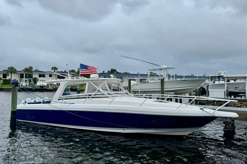 The Image of 2012 Intrepid 390 Sport Yacht docked, featuring sleek design and American flag. - 0