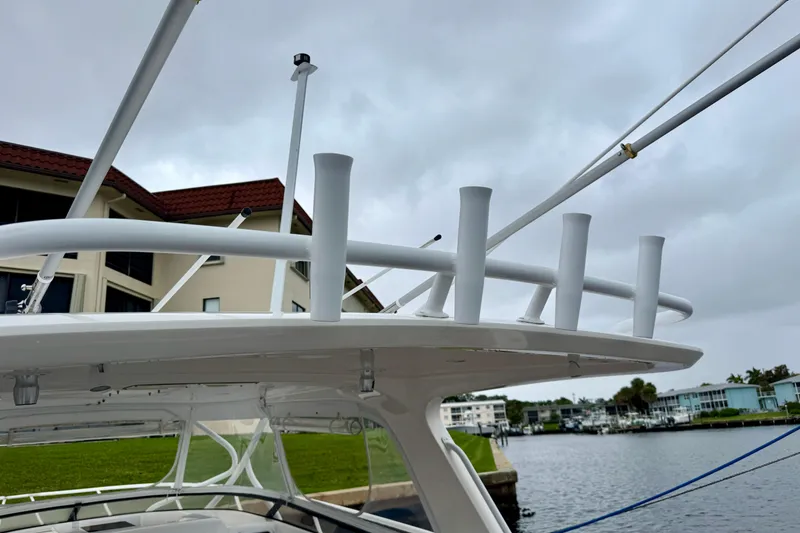 Slide: The Image of Intrepid 390 Sport Yacht 2012 with rod holders, docked near waterfront homes. - 20