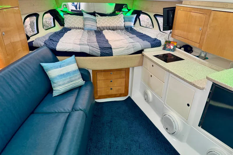 Slide: The Image of Interior of a 2012 Intrepid 390 Sport Yacht with bed, sofa, and kitchenette. - 22