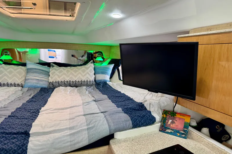 Slide: The Image of Luxurious 2012 Intrepid 390 Sport Yacht cabin with cozy bedding and mounted TV. - 30