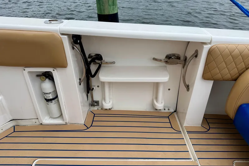 Slide: The Image of 2012 Intrepid 390 Sport Yacht deck with fire extinguisher and seating, docked by water. - 38